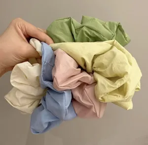 Detailed close-up showing vibrant pastel fabric scrunchies with soft texture and elasticity.