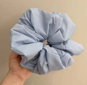 Light blue oversized scrunchie detail view, soft fabric hair tie for daily styling and elegant look.