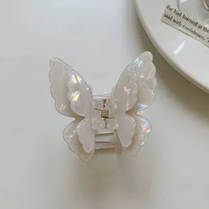Detailed close-up of a pearlescent white butterfly hair claw clip with delicate layered wings.