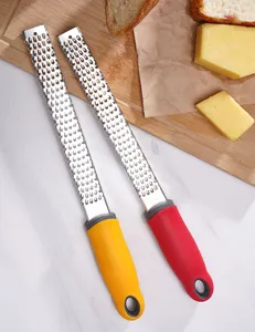 Détail de zesteur de citron et râpe à fromage en inox, poignée ergonomique pour usage facile.