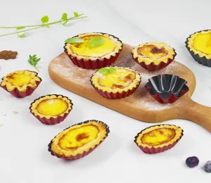 Detail view of non-stick fluted tart molds and baked egg tarts on wooden board for baking.