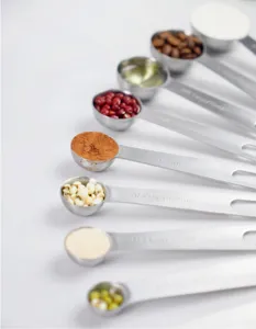 Stainless steel measuring spoons detail shot showing clear engraved capacity scales for baking.