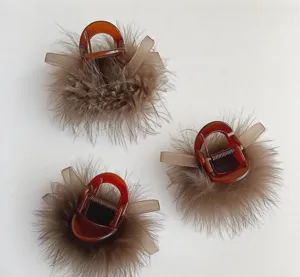 Detailed view of brown plush feather hair claw, stylish hairpin accessory for elegant buns.