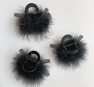 Detailed view of black feather hair claw featuring fluffy texture and chic mesh bow accent.