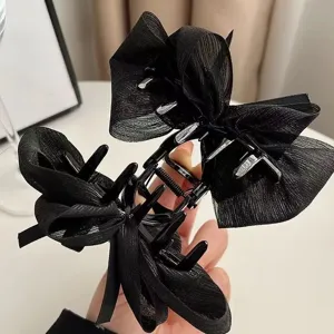 Detailed view of black mesh bow hair claw clip, elegant back head half up styling accessory.
