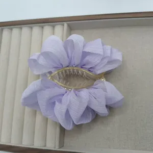Detail view of a lavender chiffon hair claw clip, elegant floral design for secure styling.