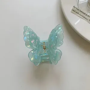 Close-up detail of the iridescent blue butterfly hair claw clip with delicate translucent texture.