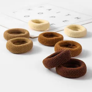 Detailed shot of brown knitted hair scrunchies, elastic hair ties for women ponytails.