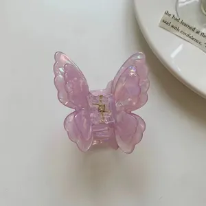 Detail view of the iridescent purple butterfly hair claw clip showing glossy acetate texture.