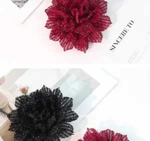 Closeup detail of sparkly metallic thread large fabric flower hair clip DIY accessory design.