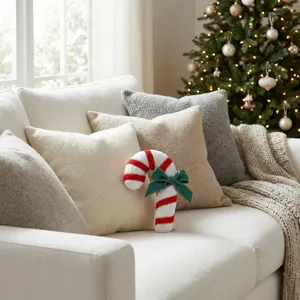 Christmas candy cane plush pillow detail view, festive holiday sofa decoration scene.