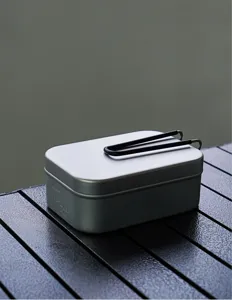 Portable aluminum camping mess tin with folding handle and capacity scale for outdoor picnic.