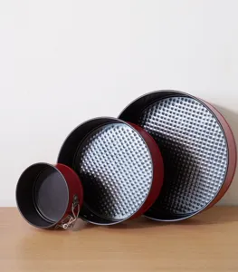 Detailed view of the red carbon steel springform cake pan set with non-stick honeycomb interior.