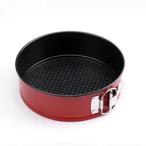 Round non-stick carbon steel cake pan with springform latch and honeycomb bottom in red color.