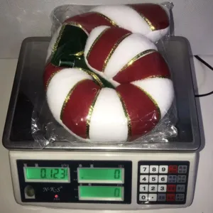 Christmas plush candy cane pillow with green bow, festive holiday home decoration item.