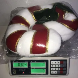 Detail view of the plush candy cane Christmas pillow, showing soft fabric and weight.