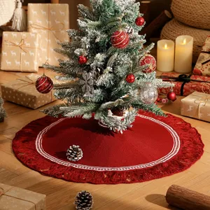 Jupe de sapin de Noël en tricot rouge avec bordure en dentelle blanche et glands festifs.