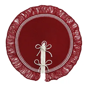 Vue détaillée de la jupe de sapin de Noël en tricot rouge avec franges et lacets blancs.