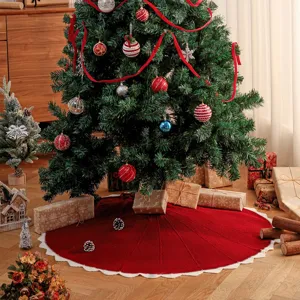 Red knitted Christmas tree skirt with white scalloped edge, festive holiday home decor detail.