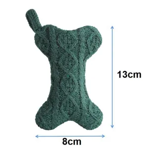 Green knitted Christmas stocking detail shot featuring festive bone-shaped hanging decor.