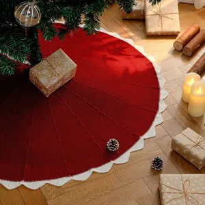 Knitted Christmas tree skirt featuring a classic red body and elegant white scalloped edge.