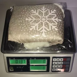 Close-up detail of the burlap Christmas tree skirt with white snowflake pattern and plush trim.