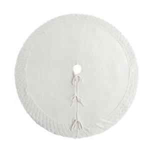 White knitted Christmas tree skirt with decorative pattern and ties for holiday decor.