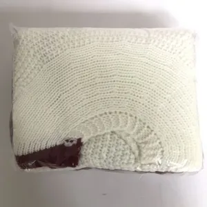 Detailed view of the white knitted Christmas tree skirt with red border, neat folded texture.