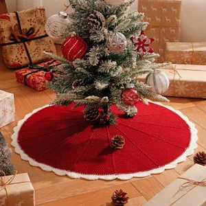 Red knitted Christmas tree skirt with white scalloped edge, festive holiday home decor base.
