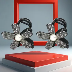 Closeup detail view of sparkling rhinestone flower hair claw clips with faux pearl center.