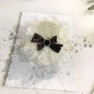 Oversized peony flower hair claw clip with glitter bow and pearl chains for thick hair styling.