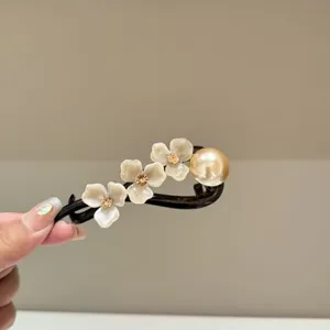 Close-up detail of vintage resin flower hair clip with pearls for women styling hair.