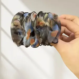 Détail de la pince à cheveux filet floral, design élégant et vaporeux pour queues de cheval.