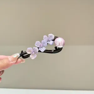 Elegant acetic acid flower hair clip with sparkling rhinestones and pearl detail.