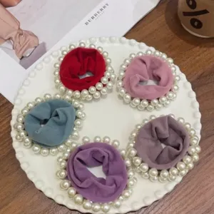 Detail view of colorful pearl scrunchies, elastic fabric hair bands for women and girls daily use.