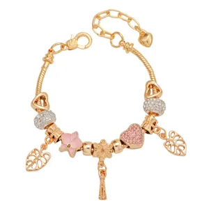 Bracelet à charms plaqué or avec fleurs en émail rose, perles de cristal et pendentifs cœurs.
