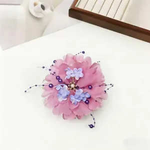 Pink flower hair claw clip with pearl beaded tassel, elegant hair accessory for women styling detail.