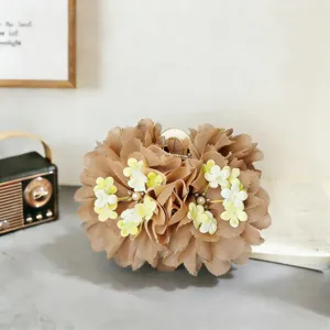 Detailed view of elegant brown fabric flower hair claw clip with pearls and floral decor.