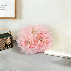 Pink mesh flower hair claw detail view, elegant floral design with pearl decoration.