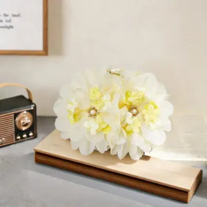 Close-up of elegant fluffy flower hair claw clip with pearl rhinestone center for stylish hair.