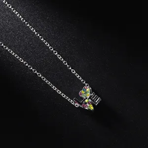 Close-up of silver-tone necklace with colorful rhinestone LOVE pendant jewelry detail.