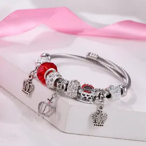 Silberner Draht-Charm-Armband mit roten Kristallperlen und süßen Kronen-Anhängern.