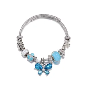 Bracelet jonc en fil argenté avec pendentif papillon en cristal bleu et perles de verre.