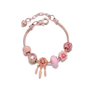 Roségoud bedelarmband met roze kristal kralen, madeliefje en dromenvanger hanger voor dames