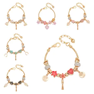 Bracelet charm doré élégant avec pendentifs fleurs, cœurs et pompons pour femmes.