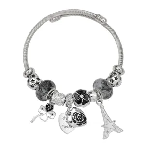 Gedetailleerde close-up van een zilveren kabelarmband met metalen kralen en diverse hangers.