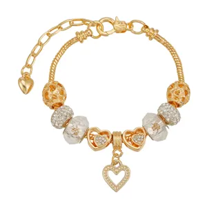 Primer plano detallado de pulsera con dijes dorados y cuentas de cristal de corazón.