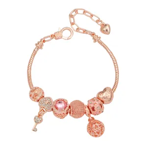 Bracelet à breloques en or rose avec cristal rose, cœur et clés pour filles élégantes.