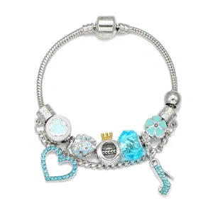 Detailopname van zilveren slangenketting bedelarmband met blauwe kristallen en hartvormige bedels.