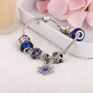 Blue crystal charm bracelet with snowflake pendant, silver snake chain DIY jewelry detail.